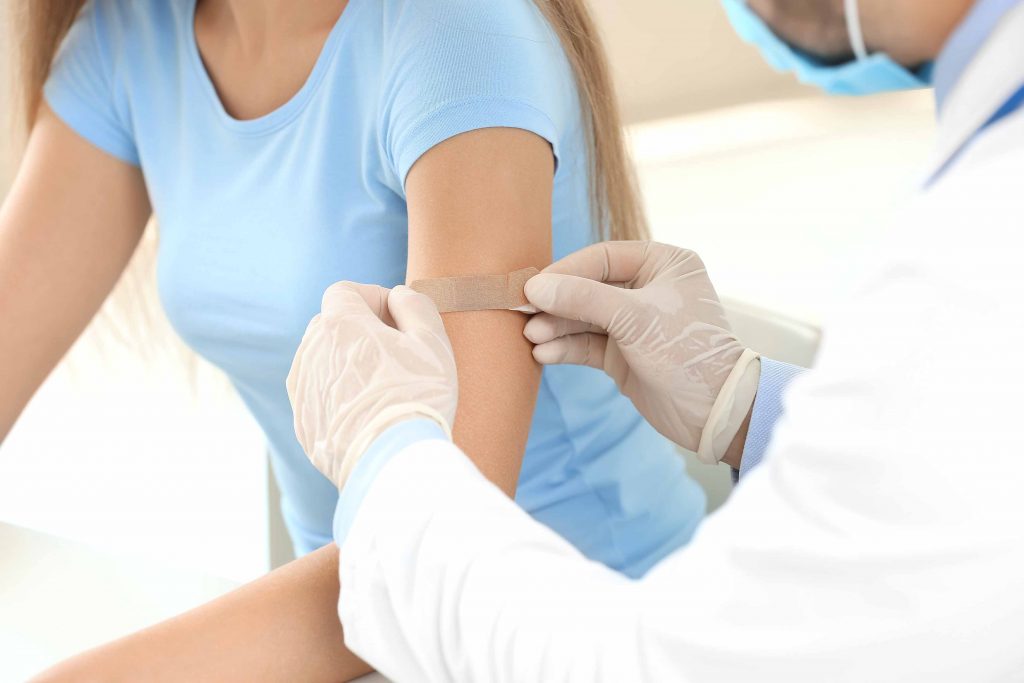 Doctor applying bandage to woman